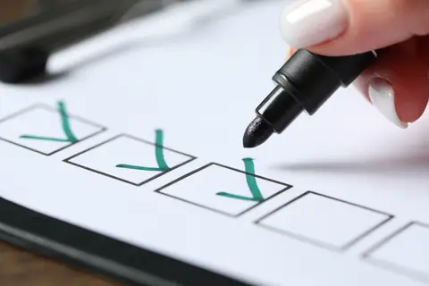Main cochant au feutre les cases d'une liste